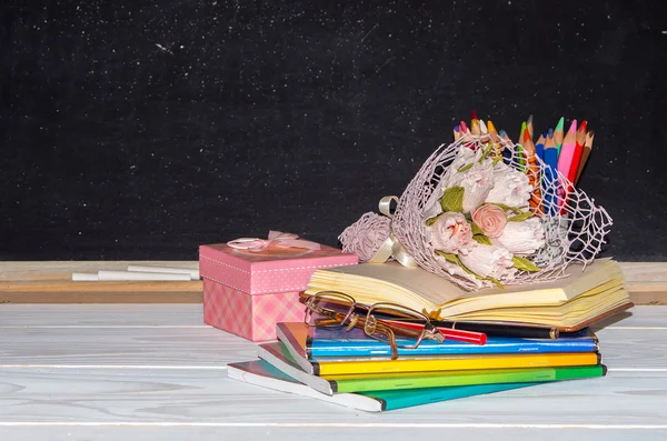 Día del Maestro. Flores y regalos; libros de texto en el escritorio del profesor . —  Fotos de Stock