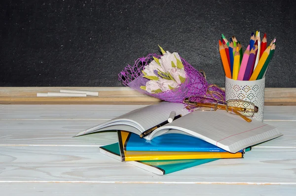 Teacher  Day. Flowers and gift; copybooks on the teacher's desk. — Stock Photo, Image