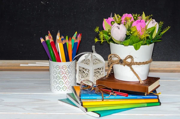 Leraar dag. Bloemen en cadeau; copybooks op de teacher's Bureau. — Stockfoto