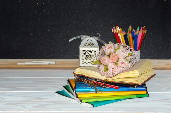 Den učitelů. Květiny a dárky; sešity na stole učitele. — Stock fotografie