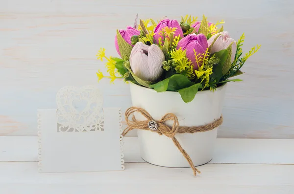 Decorative flower in a pot and gift with a card — Stock Photo, Image