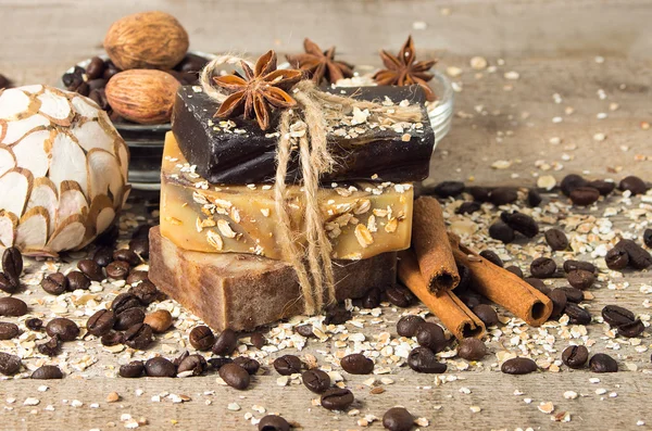 Jabón hecho a mano con granos de café y especias en un fondo de madera — Foto de Stock