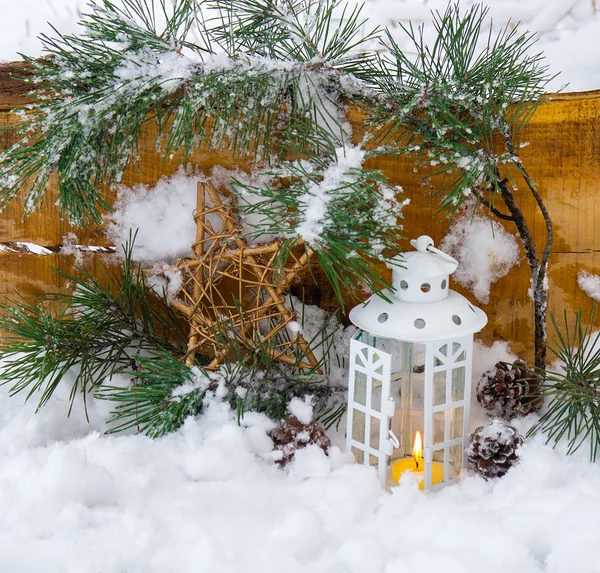 Lanterne décorative brûlant dans la neige avec une branche de conifères — Photo