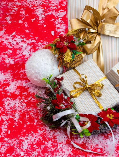 Con cinta y corona con flores de poinsettia en un backgro rojo — Foto de Stock