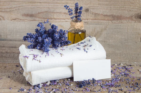 Лавандова олія, квіти лаванди та білі рушники для ванни — стокове фото