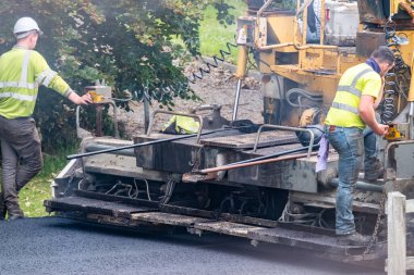 DONEGAL, IRELAND - 12 Haziran 2020: Covid 19 'un kapatılmasından sonra yeniden açılması sırasında Asphalting Paver makinesini tamir etmeye çalışan