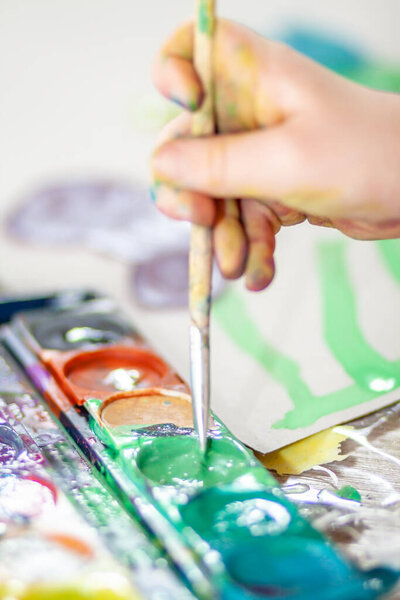 Маленькая девочка использует акварель дома во время пандемии изоляции