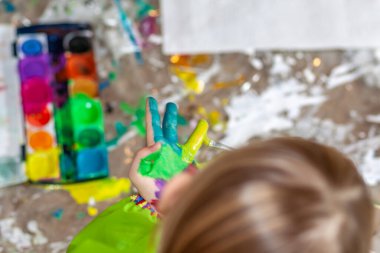 Salgın sırasında evde suluboya kullanan küçük bir kız.