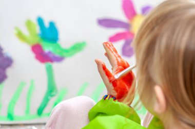 Salgın sırasında evde suluboya kullanan küçük bir kız.