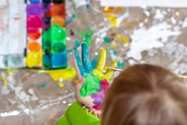 Salgın sırasında evde suluboya kullanan küçük bir kız.