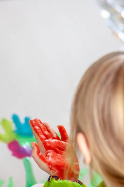 Salgın sırasında evde suluboya kullanan küçük bir kız.