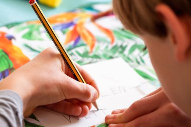 Kağıda yazan çocuk - Covid 19 salgını sırasında ödev