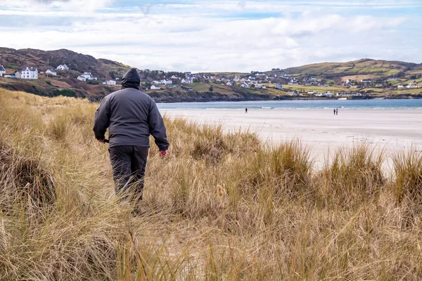 Hombre caminando en las dunas de Portnoo, Narin, playa en el Condado de Donegal, Irlanda. — Foto de Stock