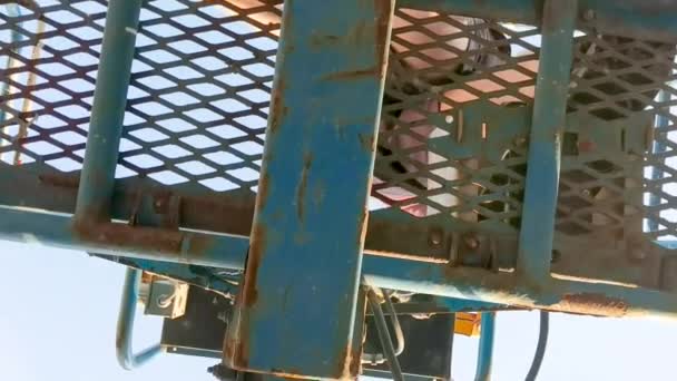 View from underneath of worker on cherry picker — Stock Video