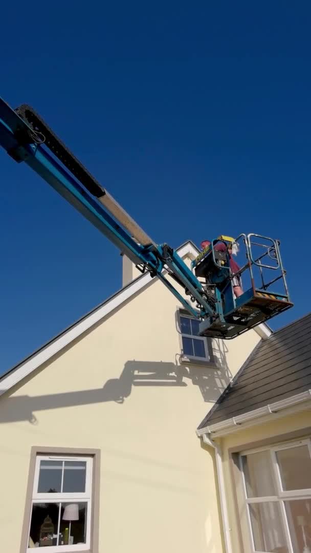 Trabalhador em uma plataforma de acesso aéreo, picador de cereja, casa de limpeza — Vídeo de Stock