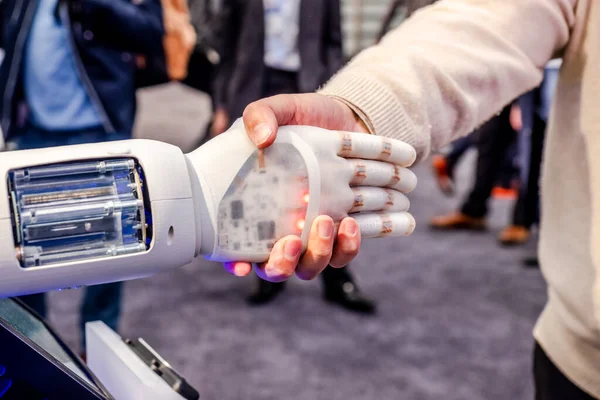 La mano humana y los robots como símbolo de conexión entre las personas y la tecnología de inteligencia artificial — Foto de Stock