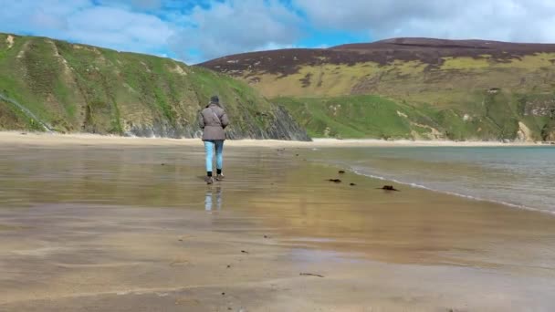 Senhora andando na bela praia em Malin Beg no Condado de Donegal - Irlanda — Vídeo de Stock