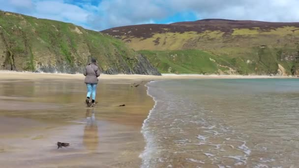 Senhora andando na bela praia em Malin Beg no Condado de Donegal - Irlanda — Vídeo de Stock
