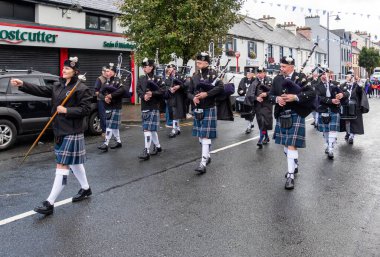 GLENTIES, COUNTY DONEGAL, IRELAND - 14 Eylül 2025: St. Nauls Pipes and Drums ana caddedeki ücretsiz Glenties Hasat Fuarı 'nda sahne alıyor.