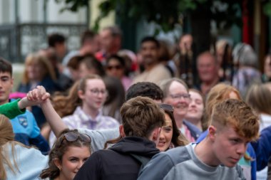 DUNGLOE, COUNTY DONEGAL, IRELAND - 31 Temmuz 2025: Yerliler ve ziyaretçiler Dungloe Uluslararası Sanat Festivali 'nden Mary' nin keyfini çıkarıyorlar.