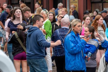 DUNGLOE, COUNTY DONEGAL, IRELAND - 31 Temmuz 2025: Yerliler ve ziyaretçiler Dungloe Uluslararası Sanat Festivali 'nden Mary' nin keyfini çıkarıyorlar.