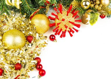 Altın Noel koronavirüsü. Kırmızı protein dikenleri ve diğer Noel süslemeleri. Beyazda izole edilmiş. Noel 2020, covid 19 salgınından ağır şekilde etkilenmiştir.