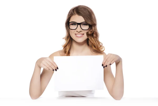 Mujer joven sonriente sosteniendo el signo blanco en blanco —  Fotos de Stock