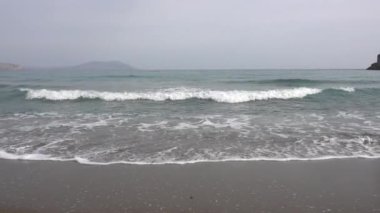 Karadeniz 'in acelesi olmayan dalgaları kumlu sahilde akıyor. Sakin bulutlu bir gün. Sis. Rahatlama