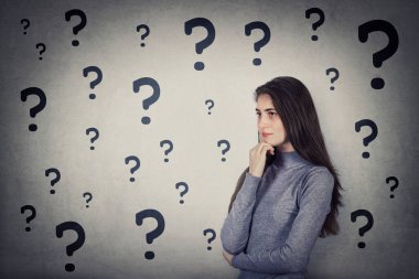 Kafası karışmış genç bir kadının birden fazla sorusu var. Elini çenesinin altında tutuyor. Düşünceli bir hareket. Kafası karışmış öğrenci kız ve farklı sorgulama işaretleri. Emin değilim. Cevap arıyorum.. 