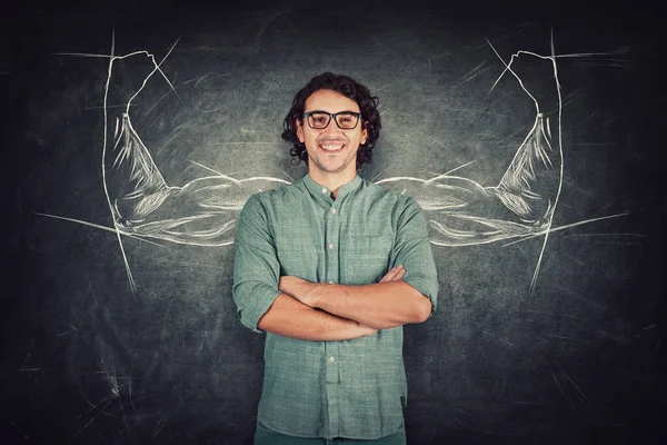 Confident student guy, long curly hair style wears eyeglasses, keeps arms crossed, strong personality, has no fears. Powerful person with biceps, muscular arms behind his back shows the inner strength