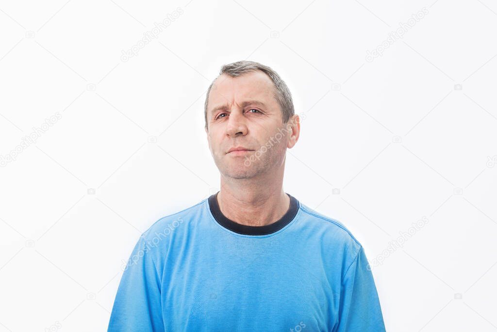 Skeptical middle aged man  looking  to camera. Middle age man with a pensive  skeptical look wearing casual t-shirt over white background.