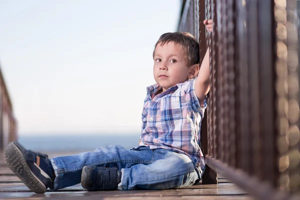 Küçük oğlan köprüde oturma