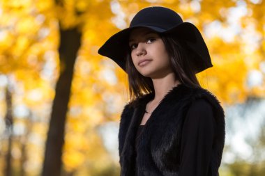 Sonbahar parkta bir şapka ile güzel kız