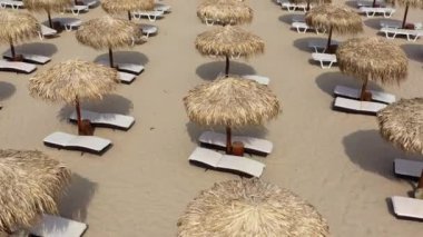 Plaj şemsiyelerinin ve kumsaldaki güneşlik yatakların havadan görünüşü.