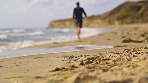 Man die over het strand loopt — Stockvideo