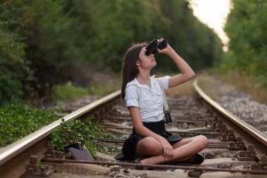 Demiryolu hattı üzerinde dürbün ile kız