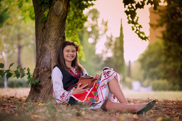 Девушка, сидящая на земле в парке — стоковое фото