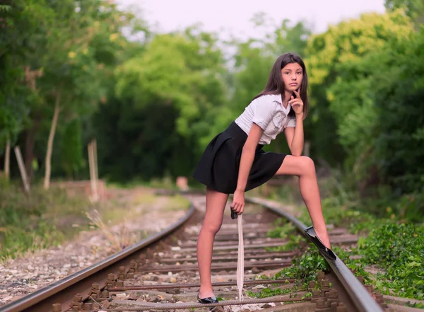 Ragazza in posa sulla linea ferroviaria — Foto Stock