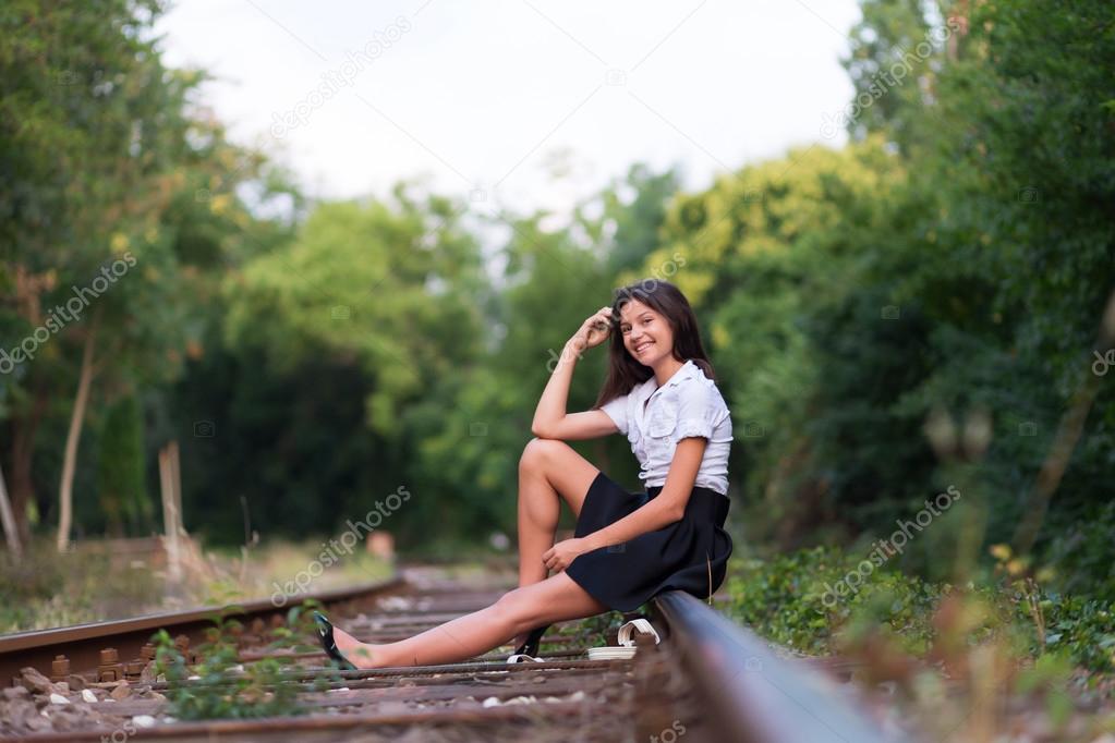 Girl sitting on the railway line