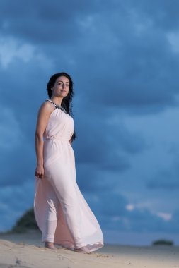 Woman walking on a sand dune