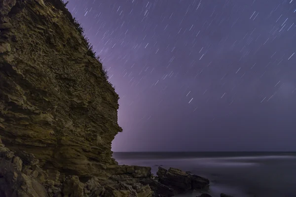 Rain of stars over rocky beach — Stock Photo, Image