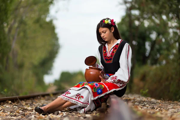 Hermosa chica sentada en la línea de ferrocarril — Foto de Stock