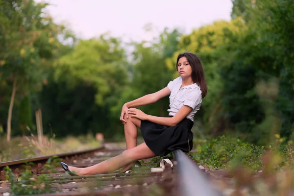 Bella ragazza seduta sulla linea ferroviaria — Foto Stock