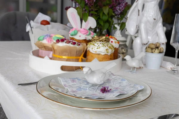 Easter. Easter cakes, lilac, hare, painted eggs, holiday, dining table with white tablecloth