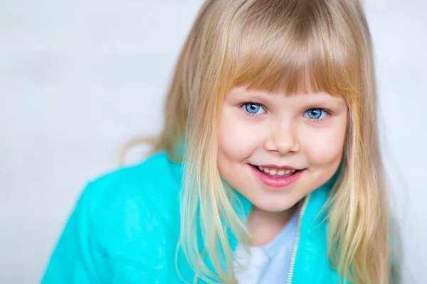Schattig klein meisje kijkt naar de camera en glimlachen — Stockfoto