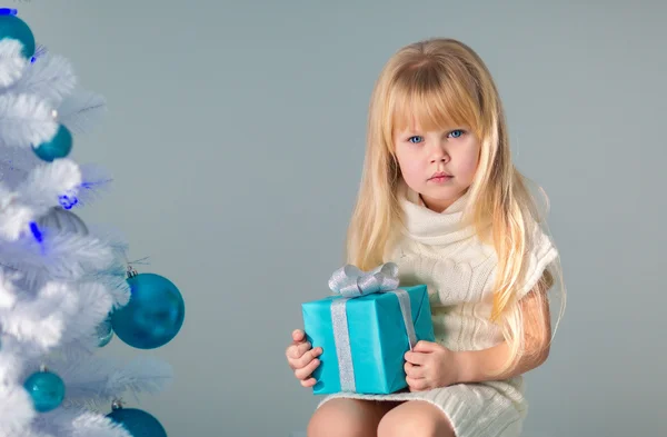 Meisje met geschenken op de kerstboom — Stockfoto