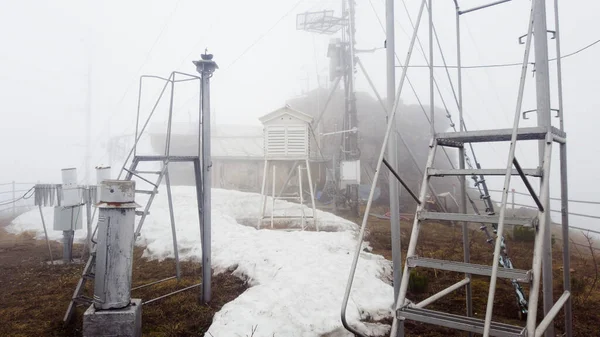 Μετεωρολογικός Σταθμός Και Μεγάλος Σωρός Από Χιόνι Που Λιώνει Τοπίο — Φωτογραφία Αρχείου