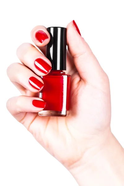 Röda nagellack i en hand — Stockfoto