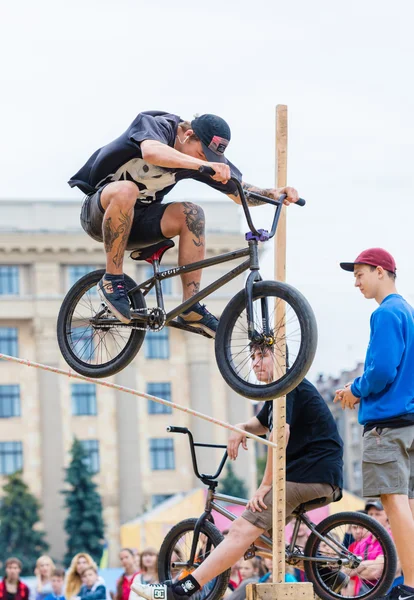 Chico joven está mostrando saltos extremos en un escenario de skate — Foto de Stock