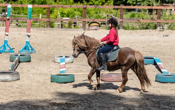 Petite fille monte un cheval — Photo